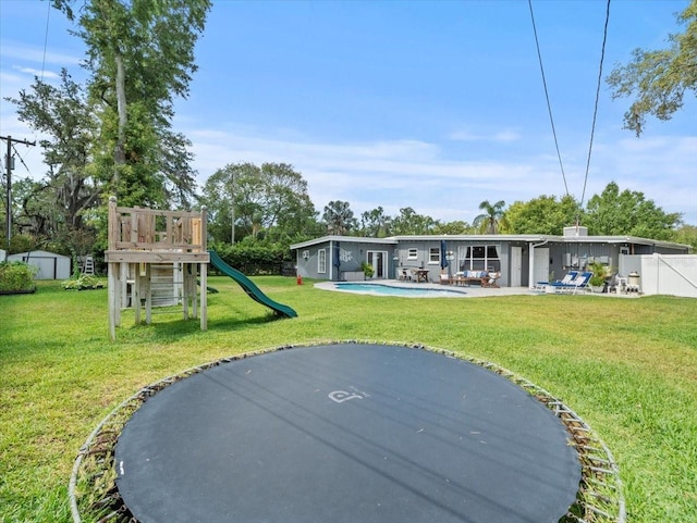 back of house with a lawn, a playground, and a patio area