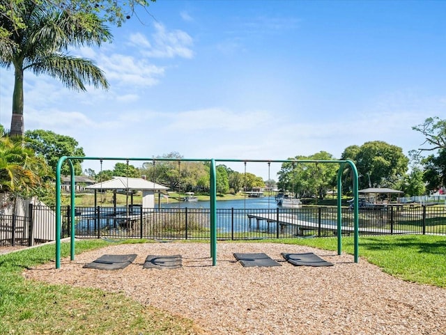 surrounding community featuring a playground and a water view