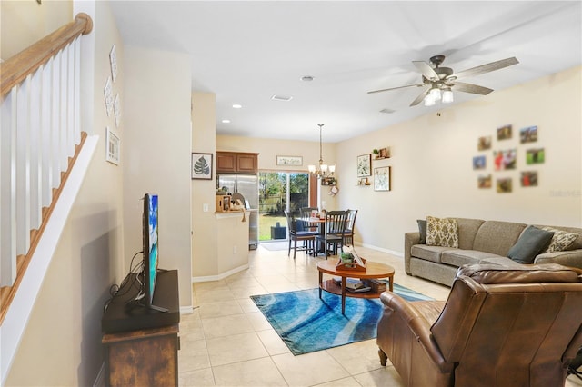 living room featuring ceiling fan with notable chandelier and light tile patterned floors