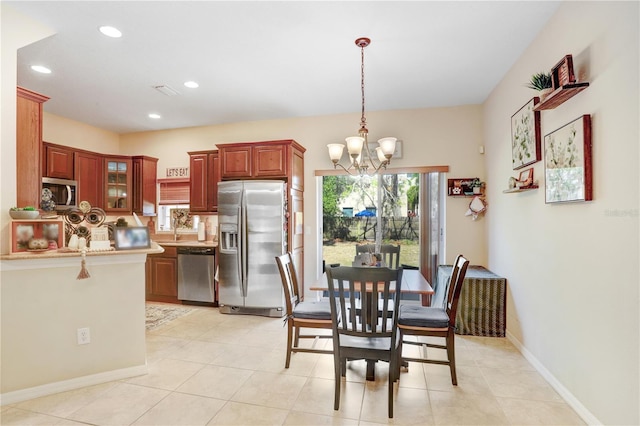 dining room with light tile patterned flooring, sink, and a notable chandelier