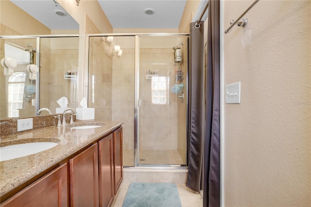 bathroom with a shower with door and vanity