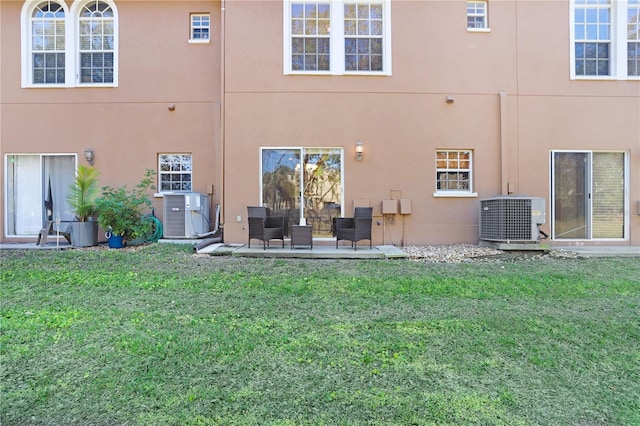 rear view of house with a yard, central AC, and a patio