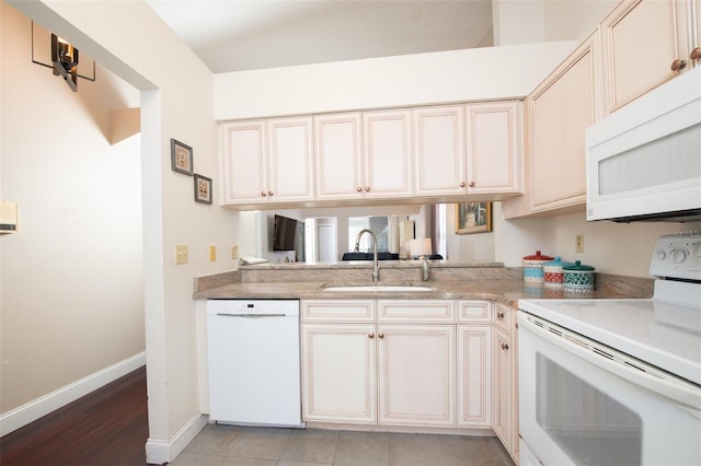 kitchen with white appliances, cream cabinets, and sink