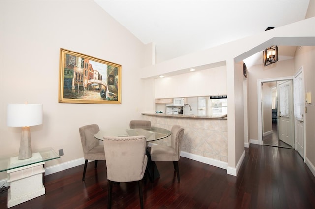 dining room with lofted ceiling, hardwood / wood-style floors, and sink