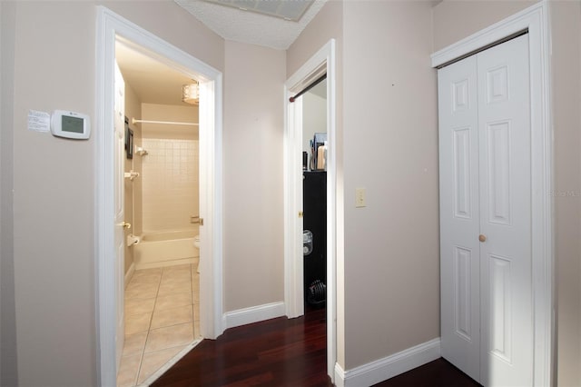 corridor featuring dark tile patterned flooring and a textured ceiling