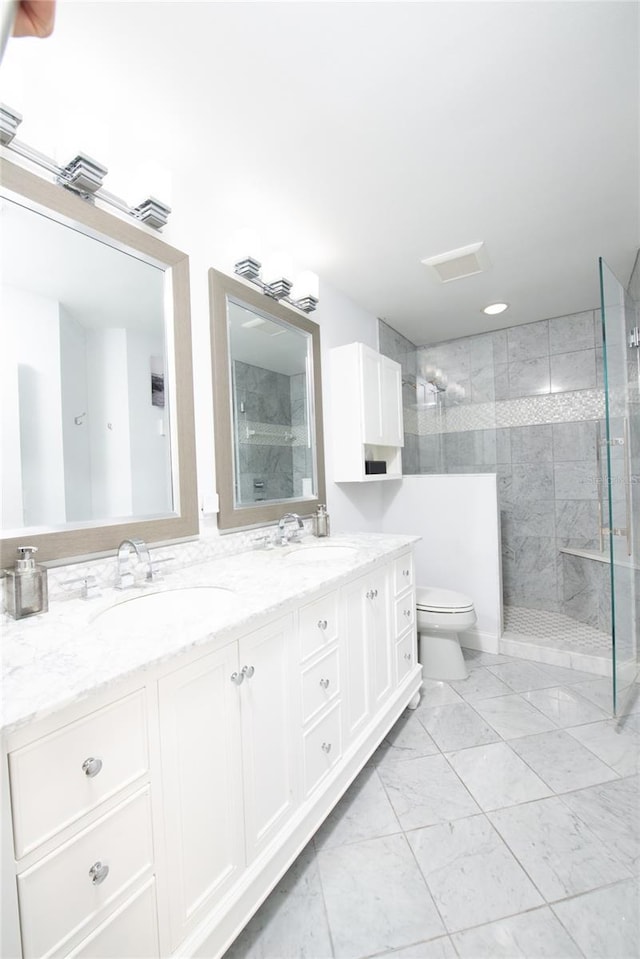 bathroom featuring vanity, toilet, and tiled shower