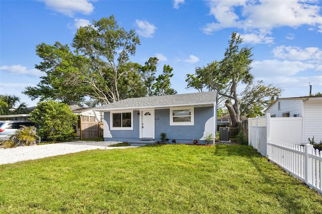 view of front facade with stucco siding, fence, central AC unit, and a front yard