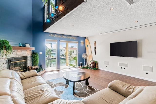 living room featuring hardwood / wood-style floors, a textured ceiling, and a fireplace