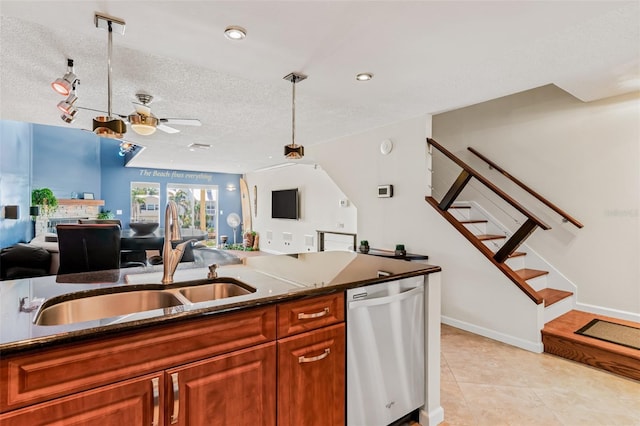 kitchen featuring stainless steel dishwasher, decorative light fixtures, sink, and a textured ceiling