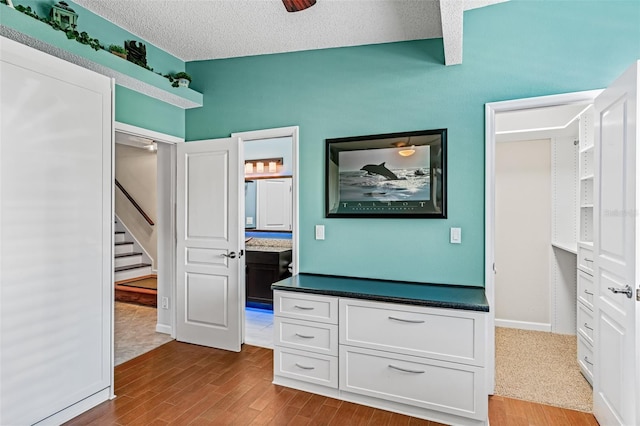 interior space featuring hardwood / wood-style flooring, ceiling fan, and a textured ceiling