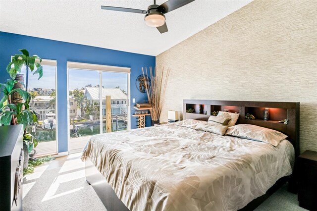 carpeted bedroom featuring ceiling fan, access to outside, a textured ceiling, and vaulted ceiling