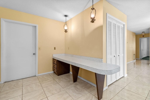 tiled dining space with a textured ceiling