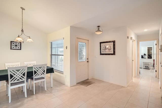 foyer entrance featuring light tile patterned floors and vaulted ceiling