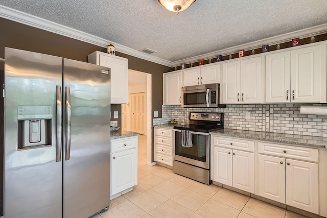 kitchen with light stone counters, crown molding, light tile patterned floors, appliances with stainless steel finishes, and white cabinets