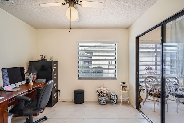 tiled office featuring a textured ceiling and ceiling fan