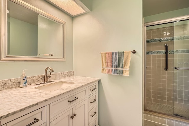 bathroom with vanity and a shower with door