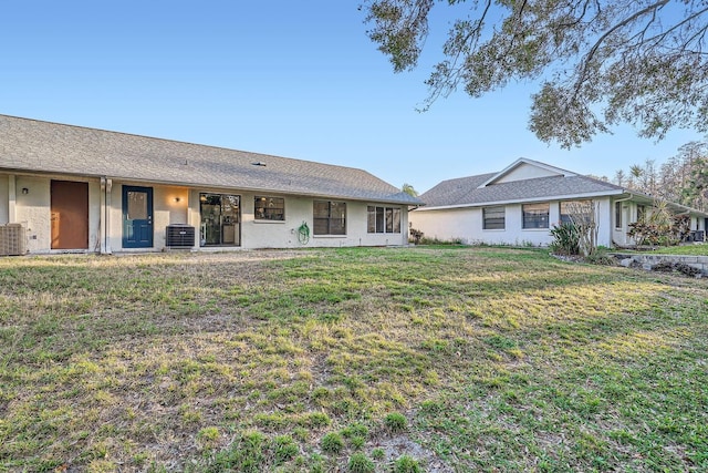 view of front of home with central AC and a front lawn