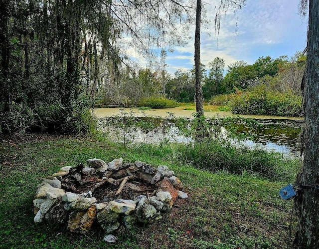 view of yard with a fire pit and a water view