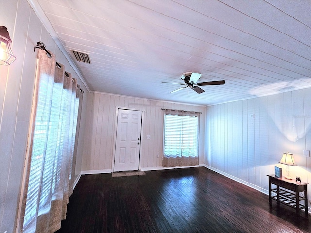 spare room with dark wood-type flooring, ceiling fan, and crown molding