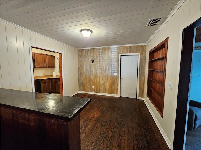 interior space featuring wood walls, kitchen peninsula, crown molding, dark wood-type flooring, and built in shelves