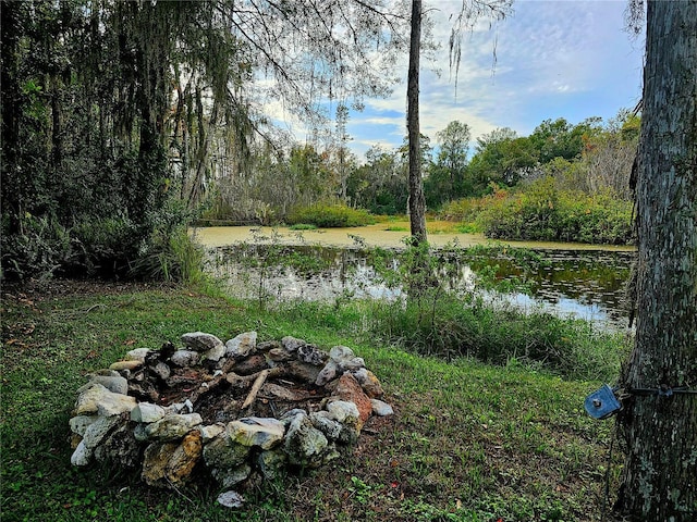 view of yard with a water view and a fire pit