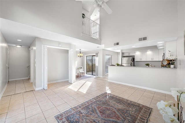 living area with light tile patterned flooring, visible vents, and baseboards