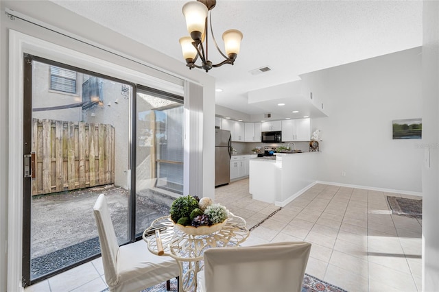 dining space featuring baseboards, visible vents, a textured ceiling, a chandelier, and light tile patterned flooring