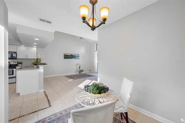 dining room with a notable chandelier, light tile patterned floors, visible vents, a textured ceiling, and baseboards