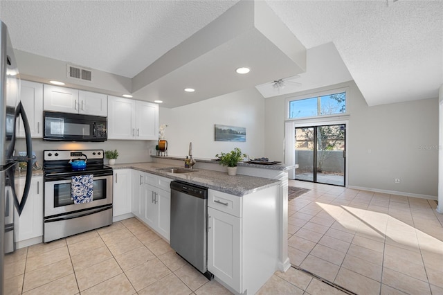 kitchen featuring stainless steel appliances, a peninsula, a sink, and white cabinetry