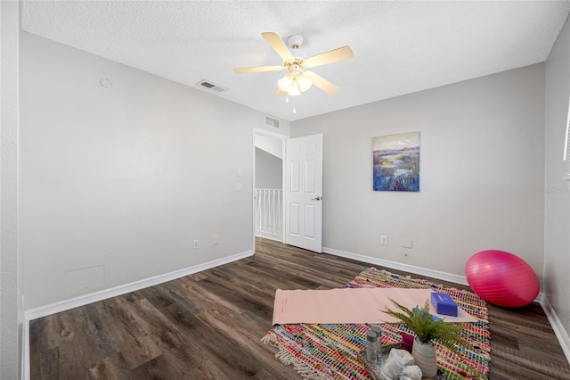 workout area featuring visible vents, dark wood finished floors, and baseboards