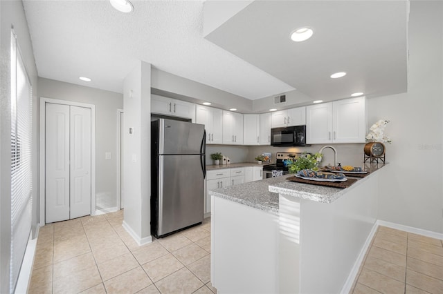 kitchen featuring light tile patterned floors, stainless steel appliances, and white cabinets