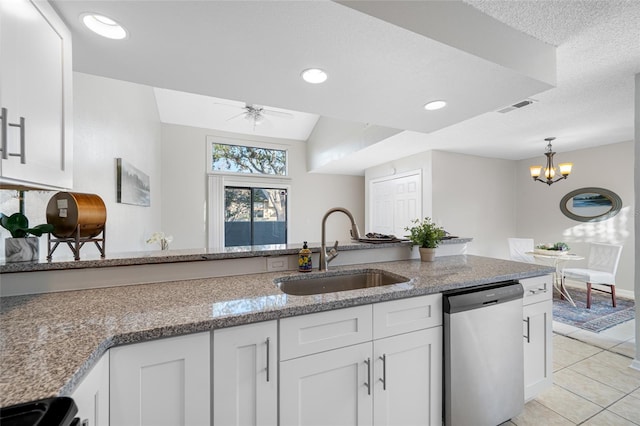 kitchen featuring visible vents, dishwasher, light stone counters, white cabinetry, and a sink