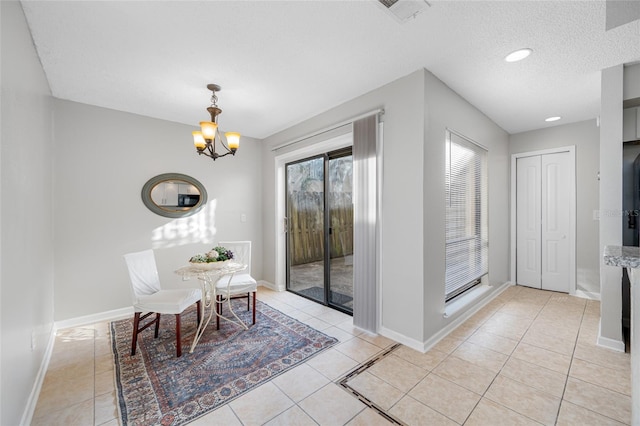 dining room featuring light tile patterned floors, a textured ceiling, visible vents, and an inviting chandelier