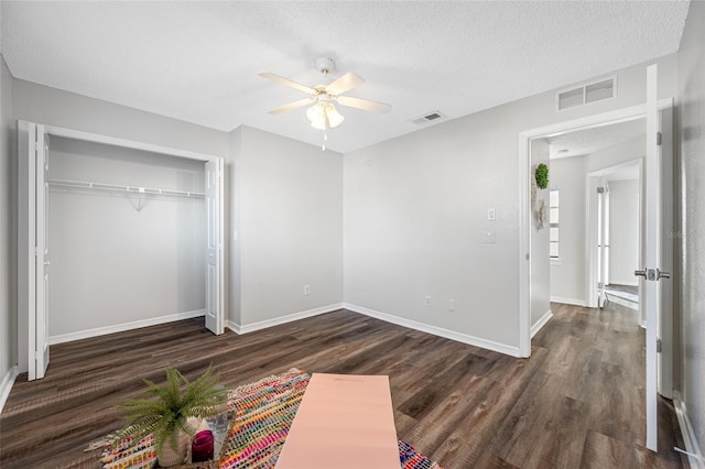 unfurnished bedroom featuring dark wood-type flooring, visible vents, and a textured ceiling