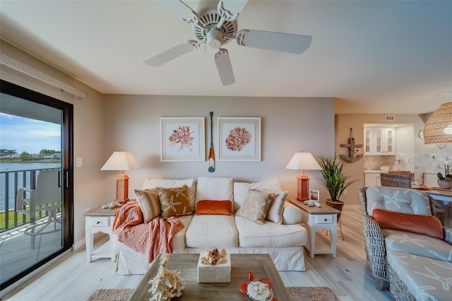 living room featuring a water view, ceiling fan, and light hardwood / wood-style floors