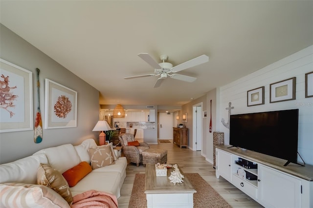 living room with ceiling fan and light hardwood / wood-style flooring