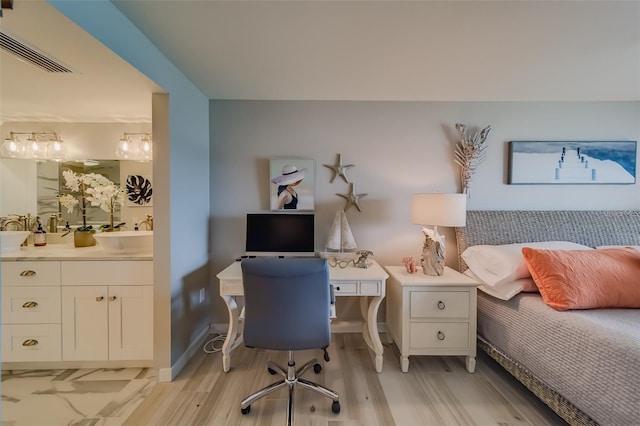 bedroom with connected bathroom and sink