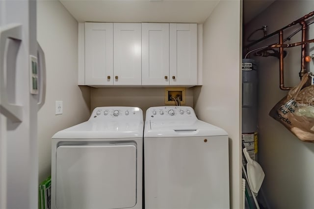 clothes washing area with cabinets and washing machine and clothes dryer