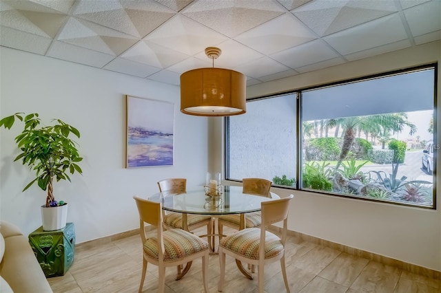 dining area featuring a wealth of natural light and a drop ceiling