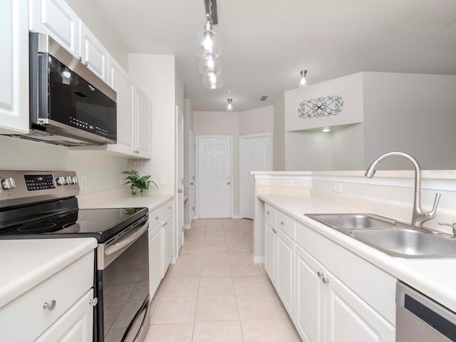 kitchen featuring sink, white cabinetry, light tile patterned floors, appliances with stainless steel finishes, and pendant lighting