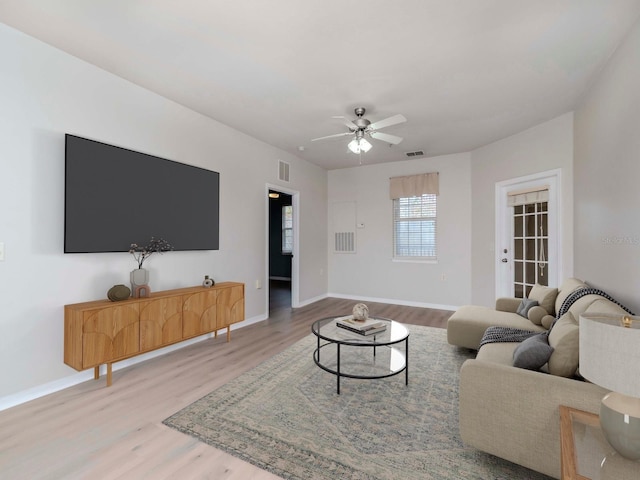 living room with wood-type flooring and ceiling fan