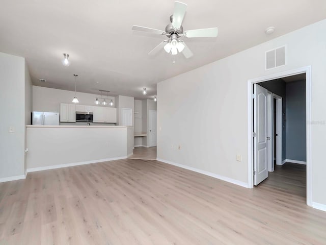 unfurnished living room featuring ceiling fan and light wood-type flooring