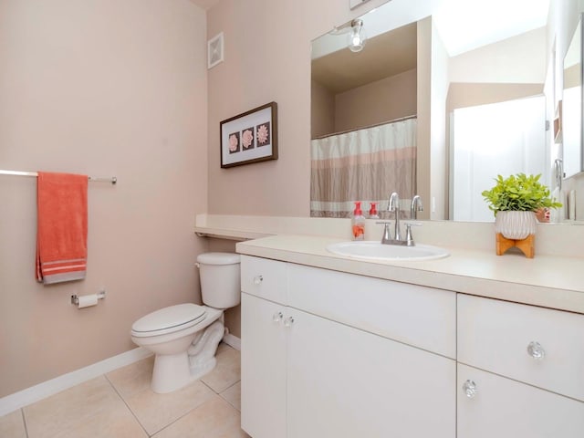 bathroom with tile patterned flooring, vanity, and toilet