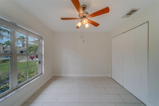 spare room with a wealth of natural light and ceiling fan