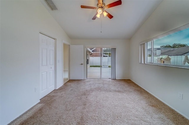 carpeted empty room with ceiling fan and lofted ceiling