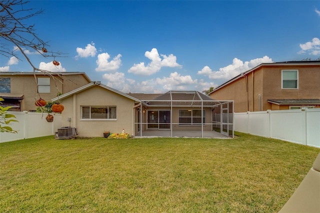 back of house featuring cooling unit, a lanai, a lawn, and a patio area