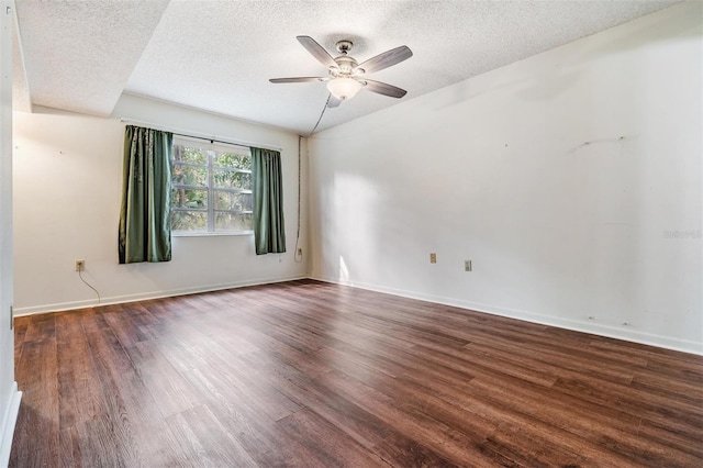 spare room with ceiling fan, dark wood-type flooring, and a textured ceiling