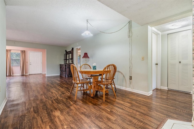 dining space featuring dark hardwood / wood-style flooring and a textured ceiling