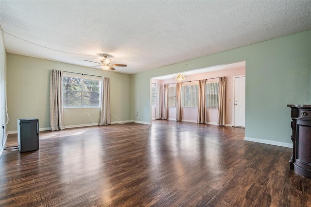 unfurnished living room with dark wood-type flooring, ceiling fan, and a textured ceiling