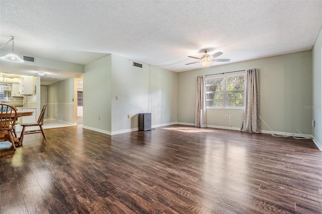 living room with dark hardwood / wood-style flooring, a textured ceiling, and ceiling fan